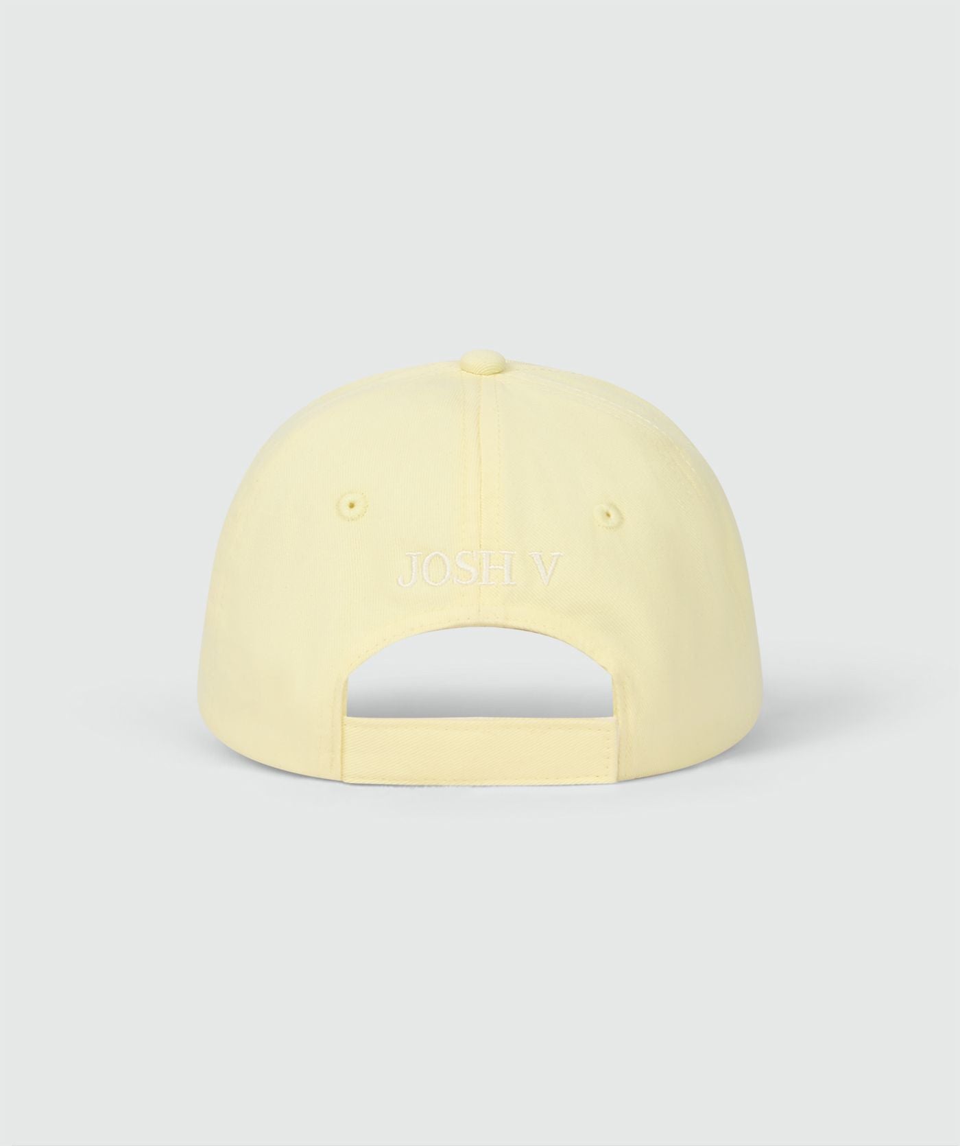 Image 5: Achterzijde van een pet in de kleur Butter Yellow met het JOSH V logo op de achterkant, weergegeven op een lichtgrijze achtergrond
