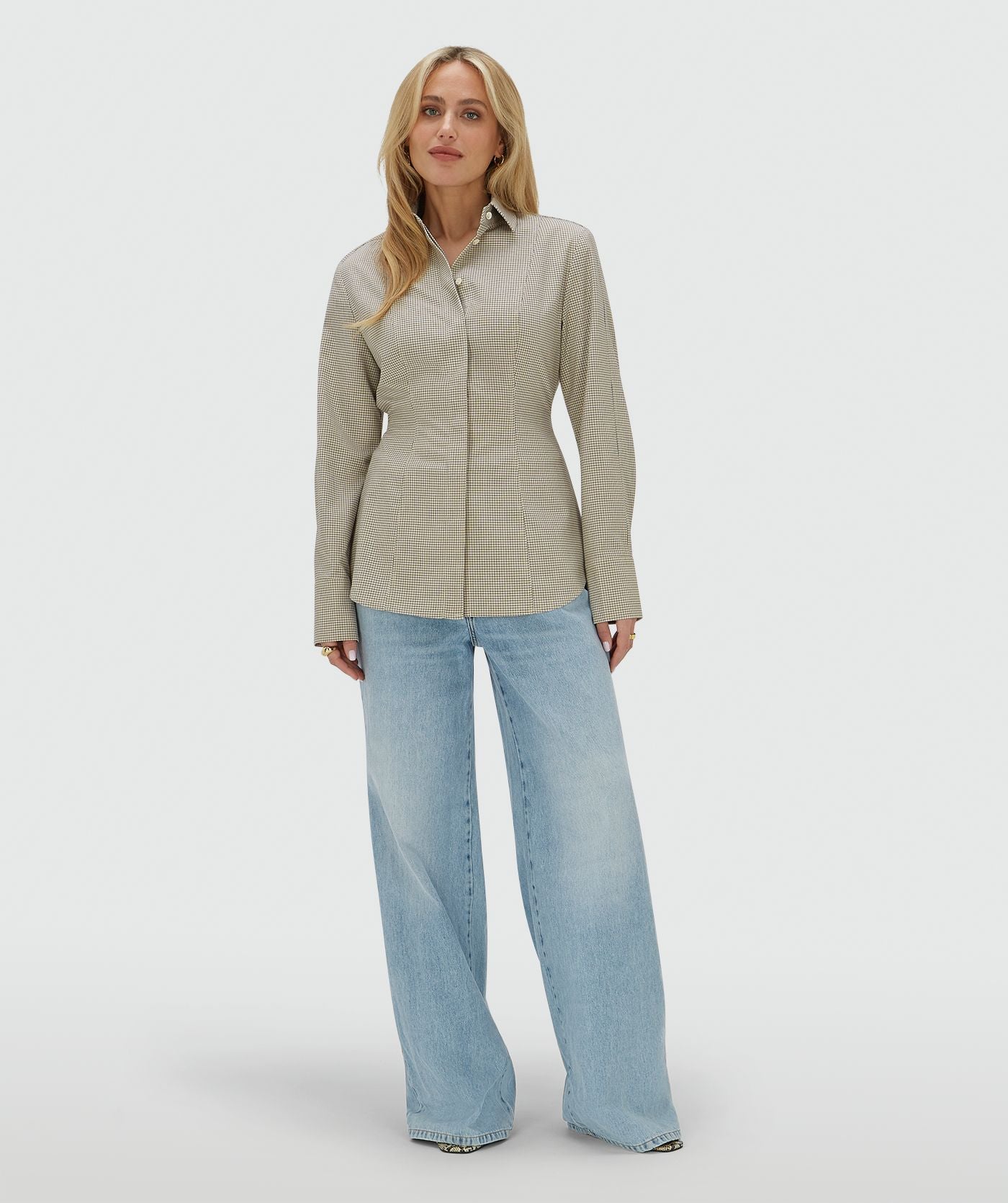 Image 24: Model draagt een fitted blouse met schoudervullingenn in het Stone Check-patroon