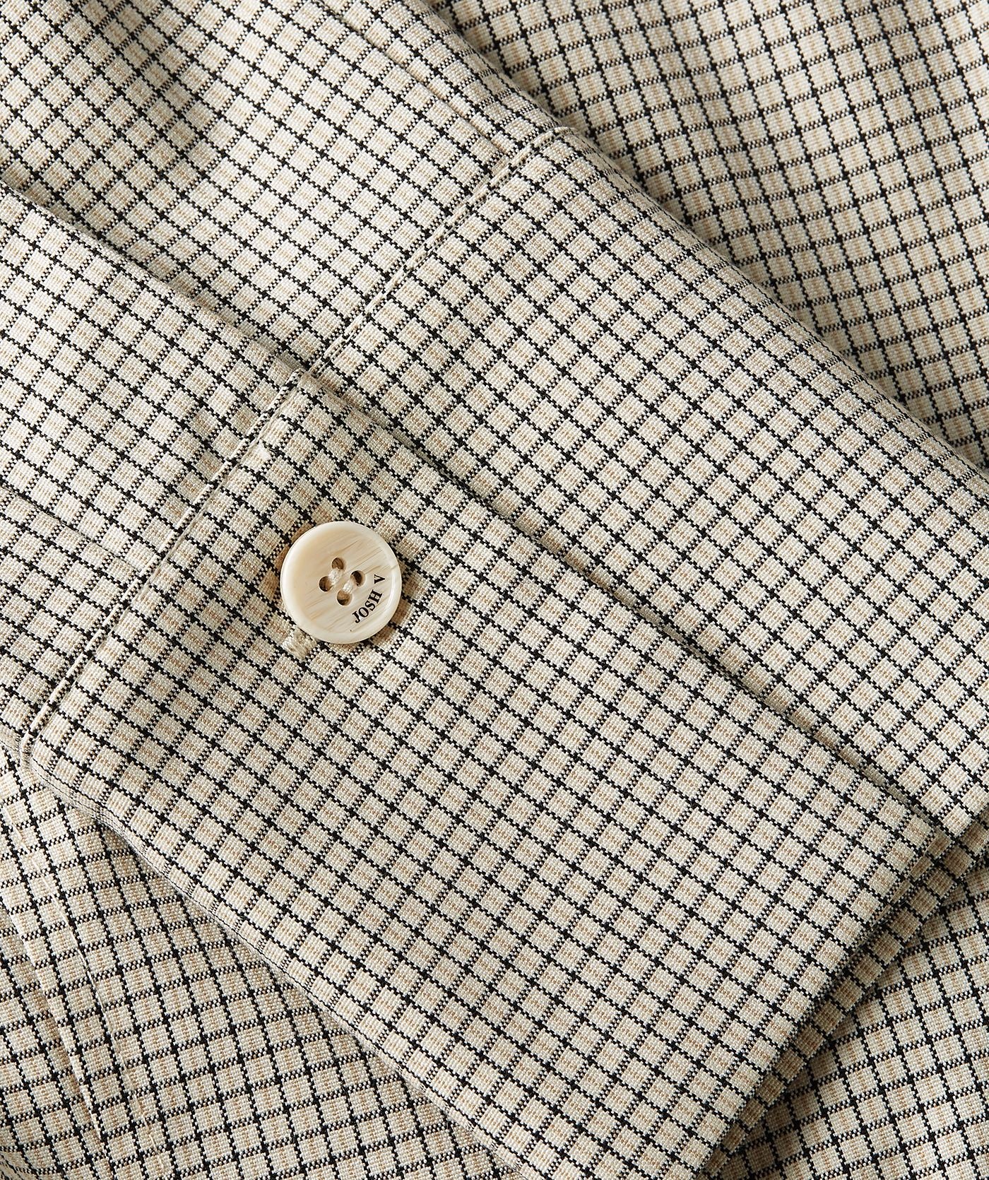 Image 36: Close-up van een fitted blouse met schoudervullingen in het Stone Check-patroon, waarin de mouw goed zichtbaar is