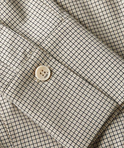 Image 36: Close-up van een fitted blouse met schoudervullingen in het Stone Check-patroon, waarin de mouw goed zichtbaar is