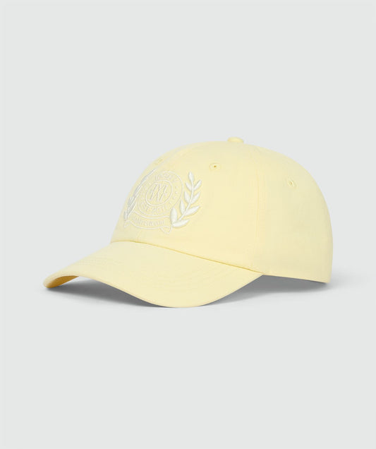 Image 3: Pet in de kleur Butter Yellow met geborduurde logo op de voorkant, weergegeven op een lichtgrijze achtergrond