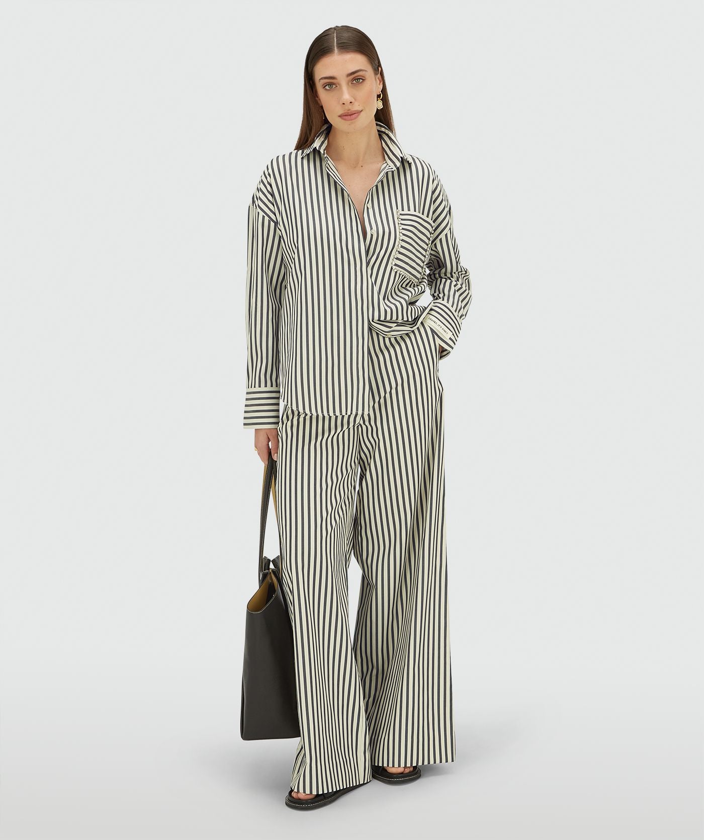 Image 4: Model draagt een oversized blouse met strepen in de kleur Blue Stripe met strass steentjes rond de borstzak