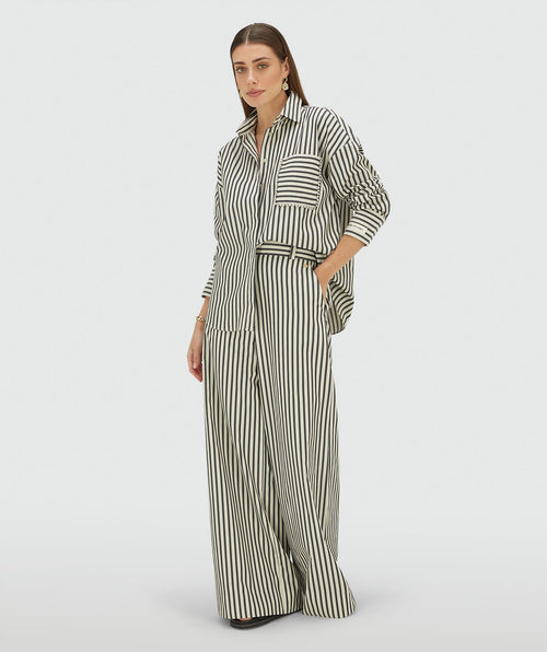 Image 1: Model draagt een oversized blouse met strepen in de kleur Blue Stripe met strass steentjes rond de borstzak