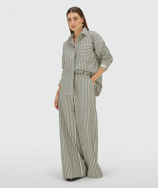 Image 1: Model draagt een oversized blouse met strepen in de kleur Blue Stripe met strass steentjes rond de borstzak