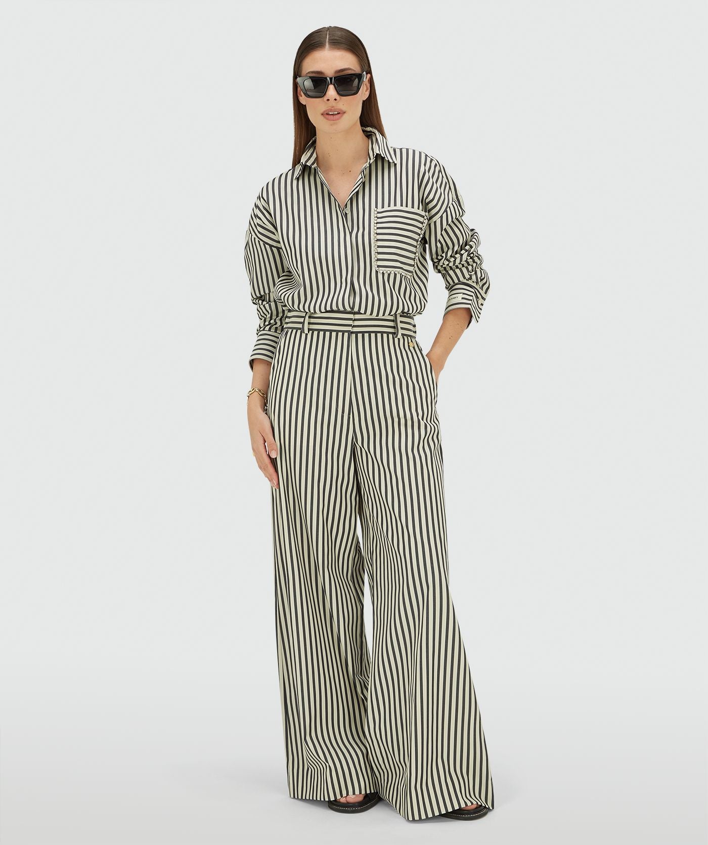 Image 3: Model draagt een oversized blouse met strepen in de kleur Blue Stripe met strass steentjes rond de borstzak