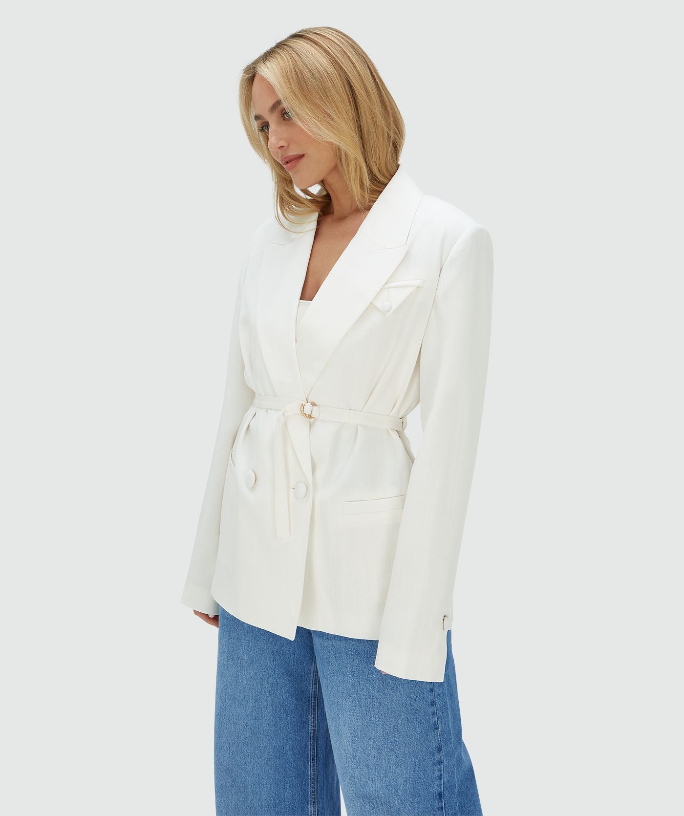 Image 5: Model draagt een Off White oversized blazer, waarbij de ceintuur aan de voorzijde zorgt voor een getailleerd effect