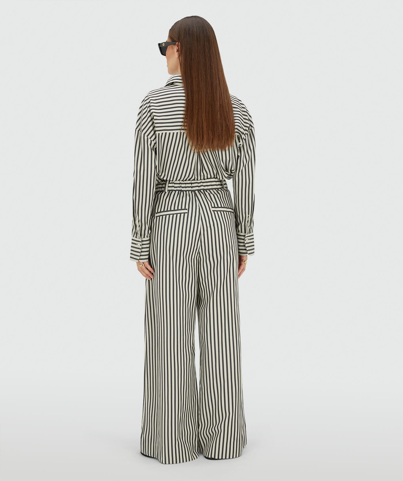 Image 11: Achteraanzicht van een model in een mid rise wide leg pantalon met strepen in de kleur Dark Blue Stripe