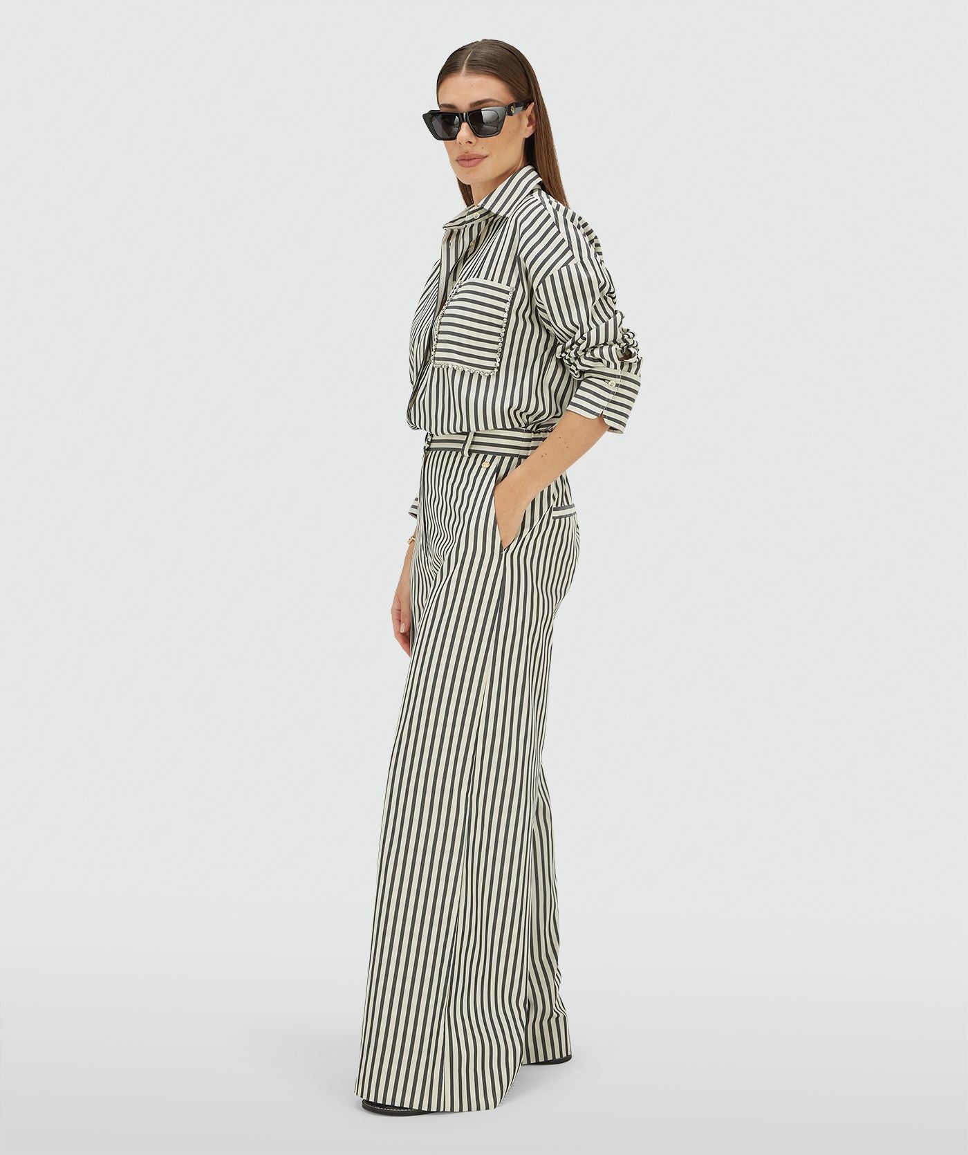 Image 9: Zijaanzicht van een model in een mid rise wide leg pantalon met strepen in de kleur Dark Blue Stripe