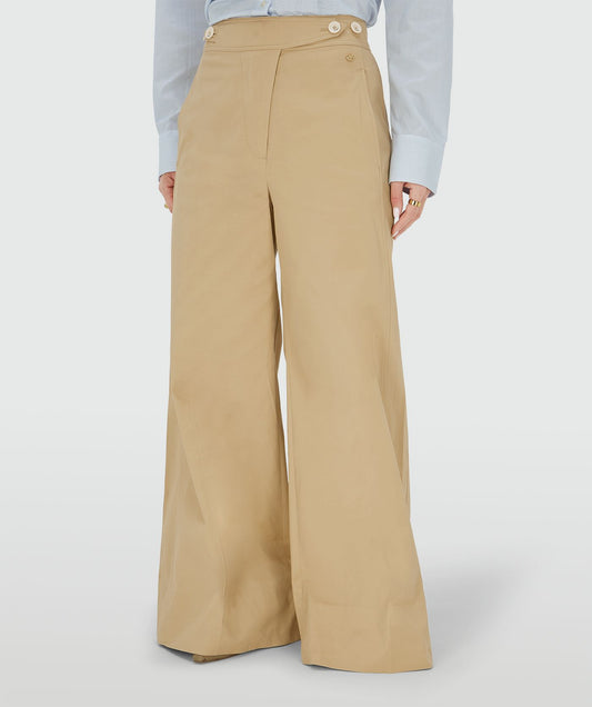 Image 2: Ingezoomd beeld waarin een model een mid rise wide leg pantalon draagt in de kleur Light Camel, voorzien van verstelbare knopen in de tailleband