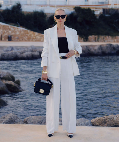 Image 55: Model draagt een high rise wide leg pantalon in het Off White