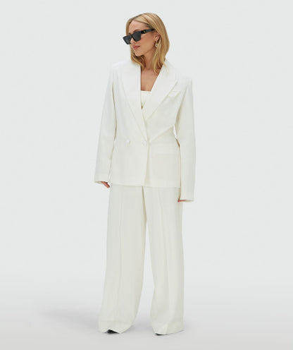 Image 43: Model draagt een high rise wide leg pantalon in het Off White