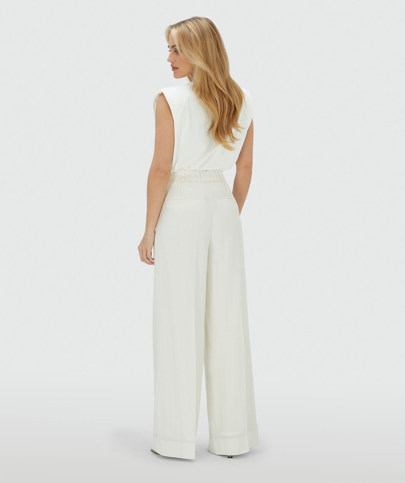 Image 45: Achteraanzicht van een model in een high rise wide leg pantalon in het Off White