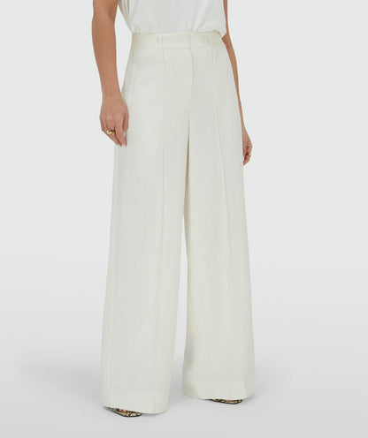 Image 37: Ingezoomd beeld waarin het model een high rise wide leg pantalon in het Off White draagt