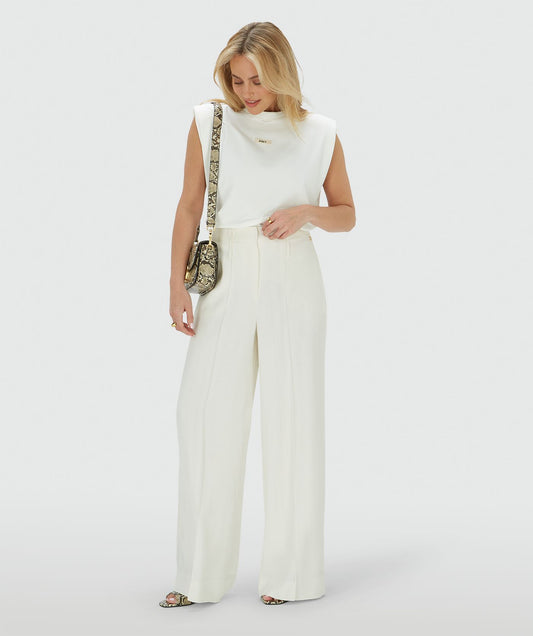 Image 35: Model draagt een high rise wide leg pantalon in het Off White