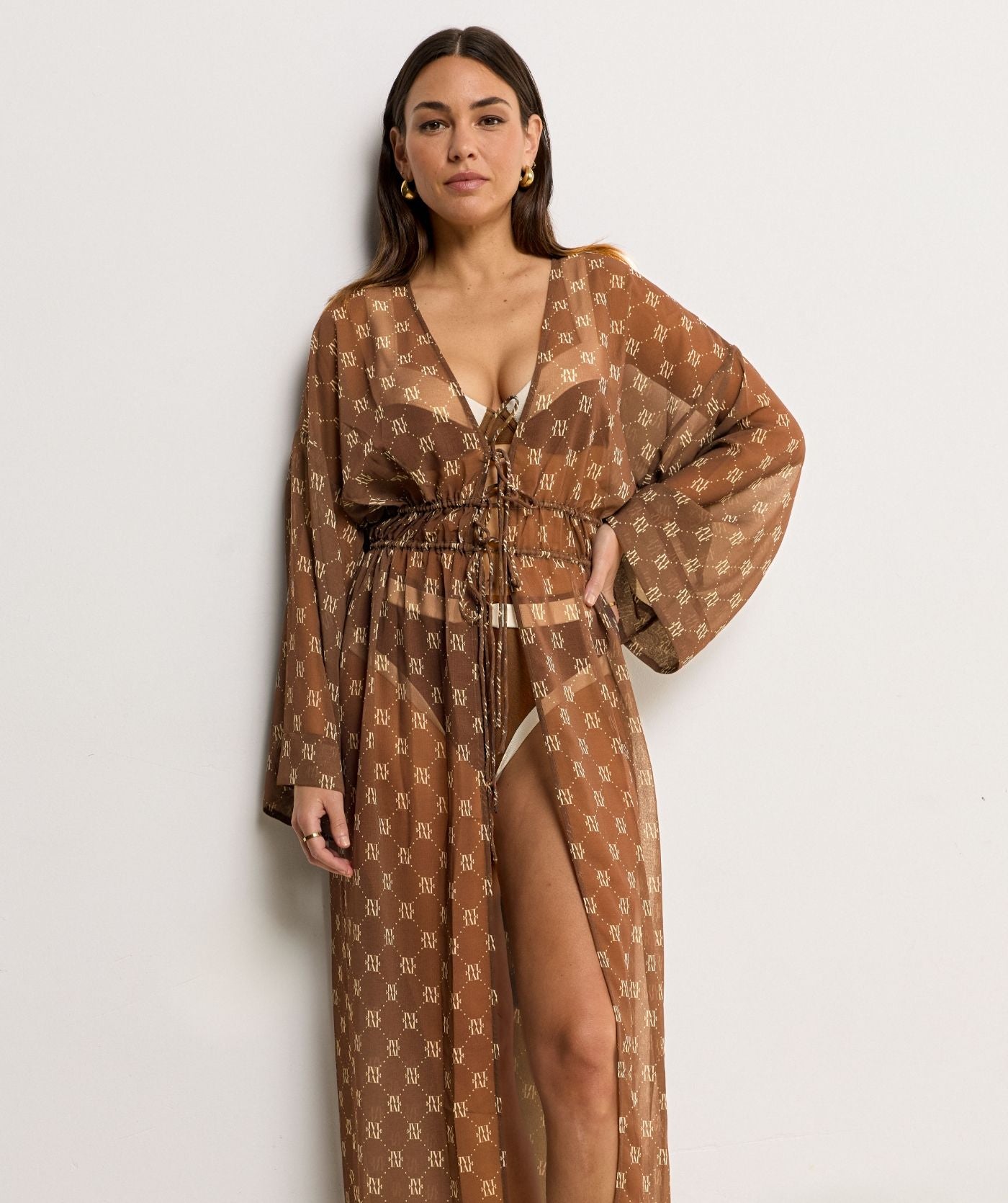 Image 50: Model draagt een oversized kimono met logoprint in de kleur Brown
