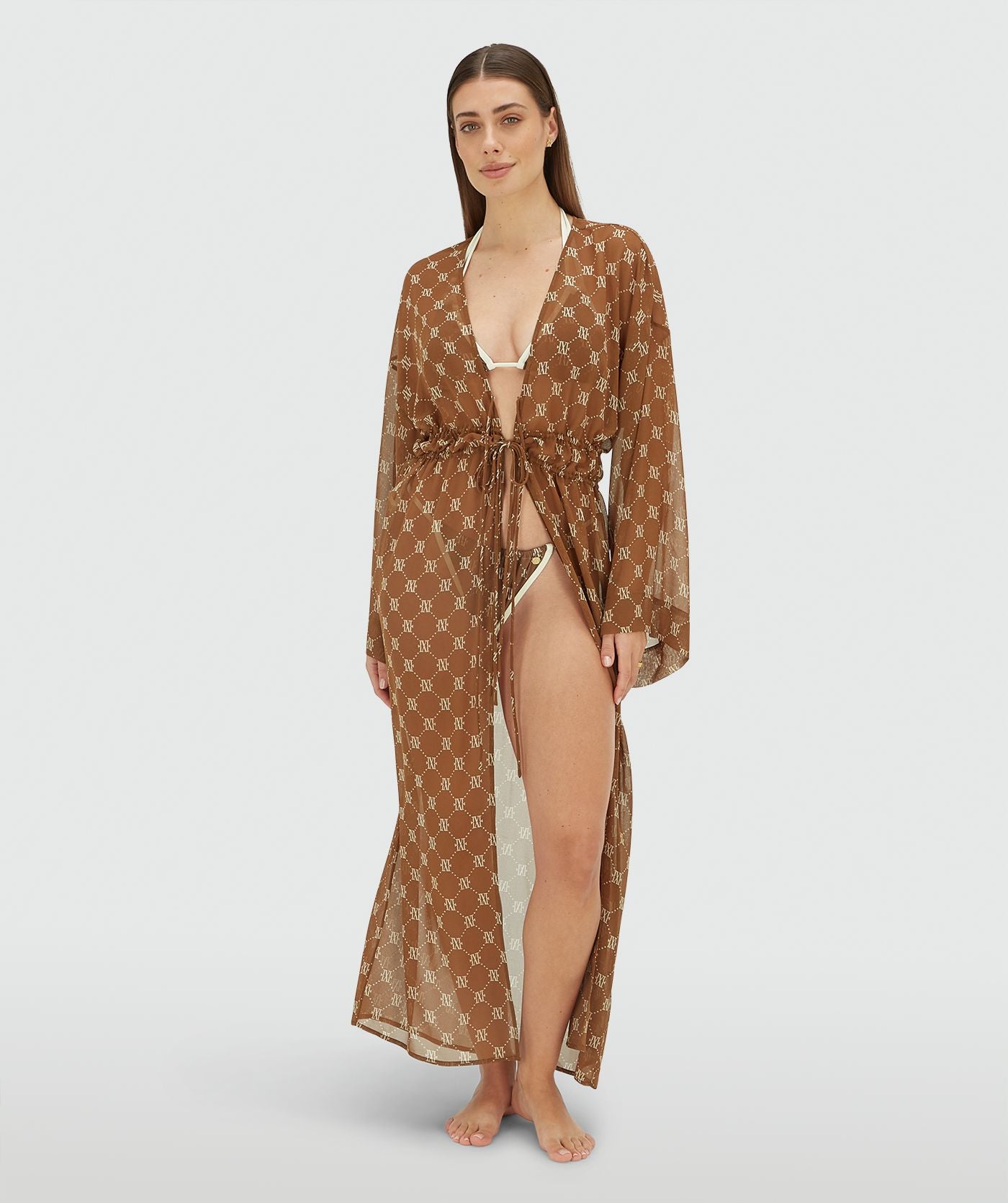 Image 32: Model draagt een oversized kimono met logoprint in de kleur Brown