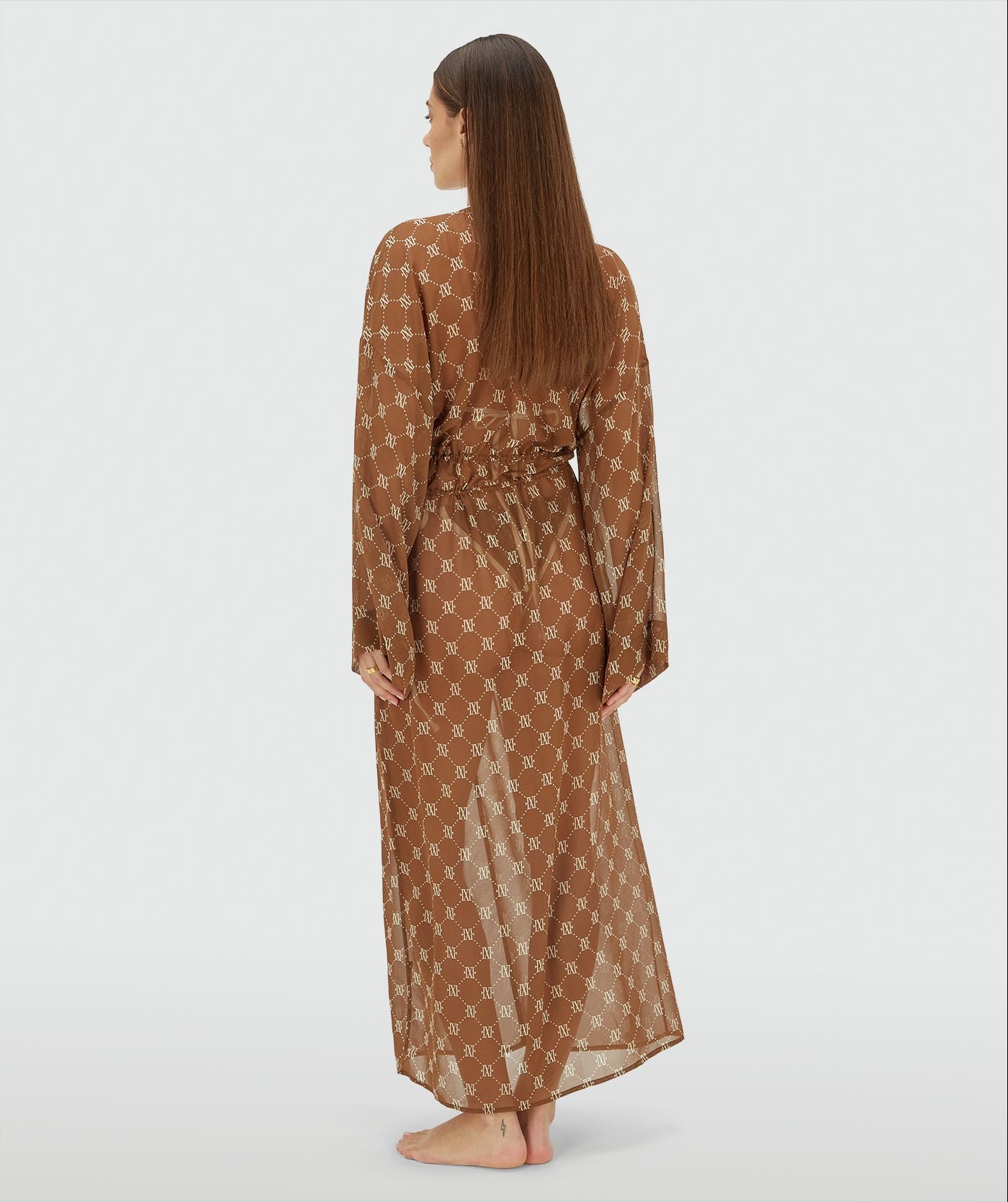 Image 42: Achterzijde van een model in een oversized kimono met logoprint in de kleur Brown