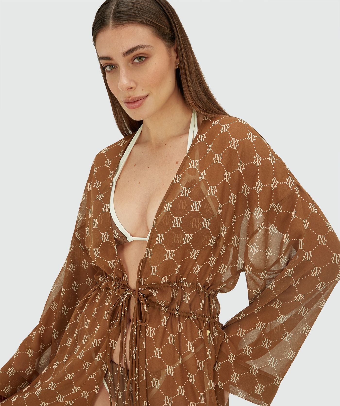 Image 38: Model draagt een oversized kimono met logoprint in de kleur Brown