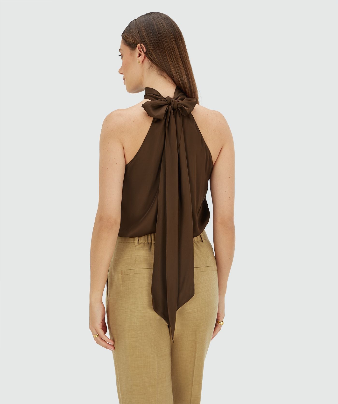 Image 15: Achterzijde van een model in een loose fit top in satijn look in de kleur Brown