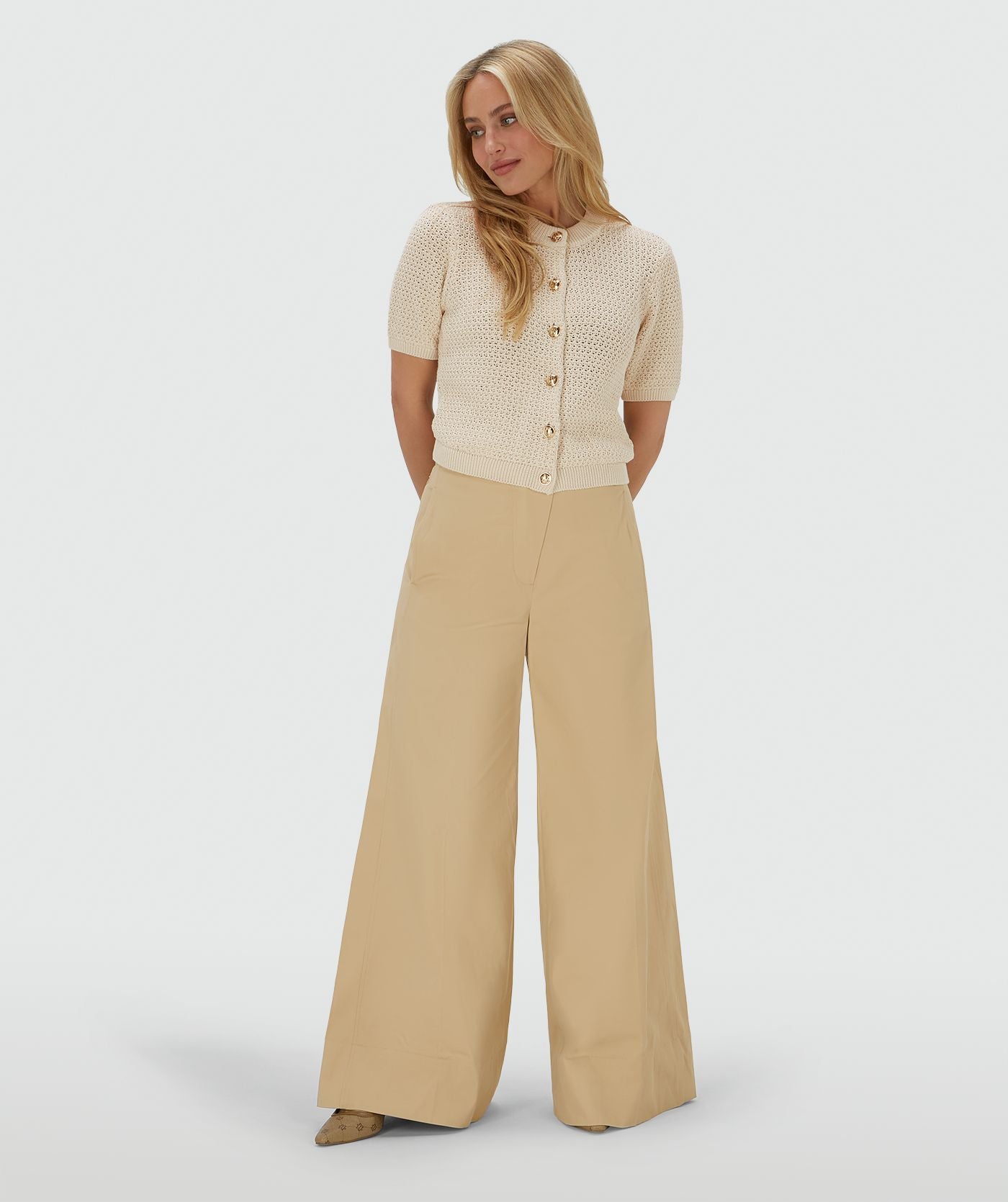 Image 16: Model draagt een ecrukleurig vest met een regular fit
