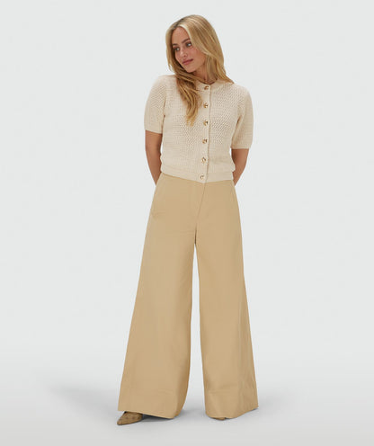 Image 16: Model draagt een ecrukleurig vest met een regular fit