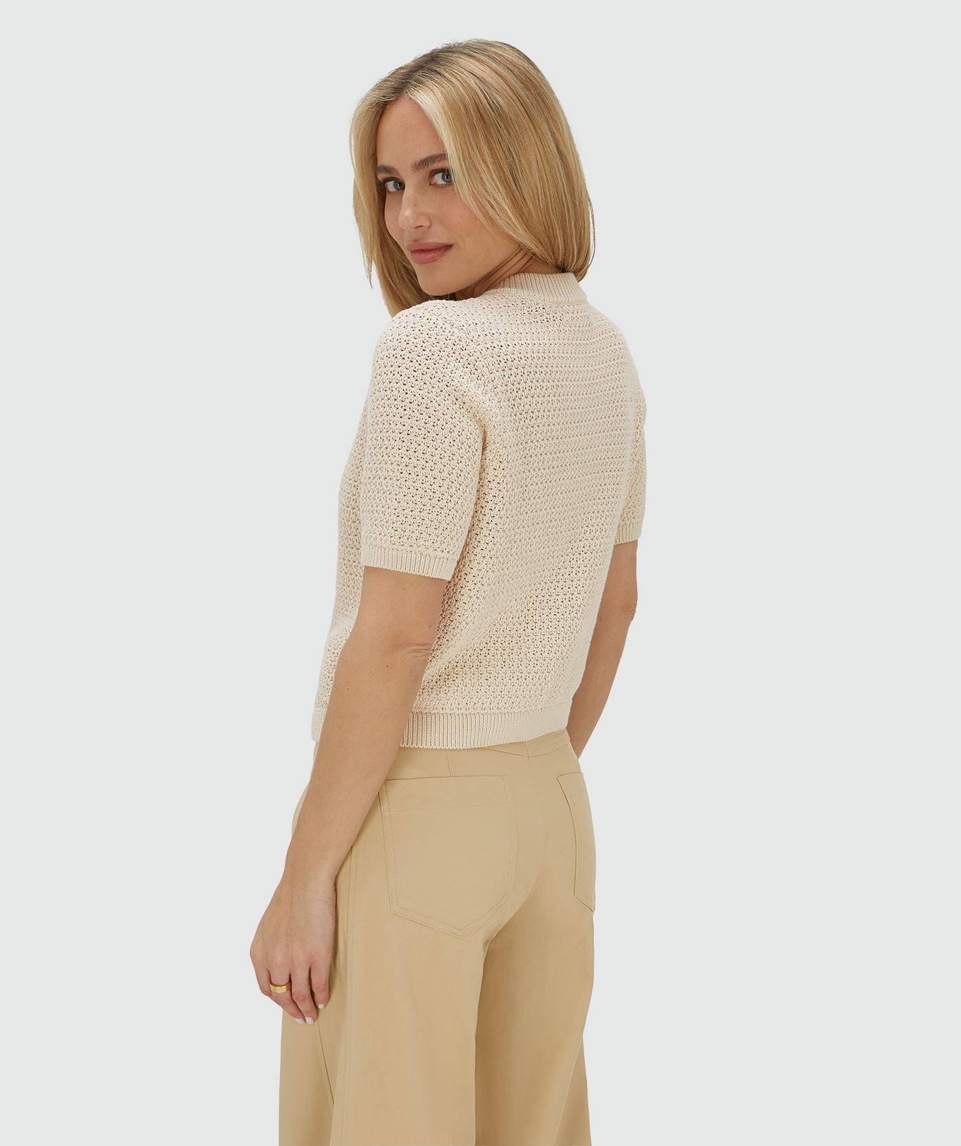 Image 18: Zijaanzicht van het model in een ecrukleurig vest met een regular fit