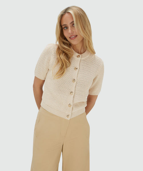 Image 14: Model draagt een ecrukleurig vest met een regular fit