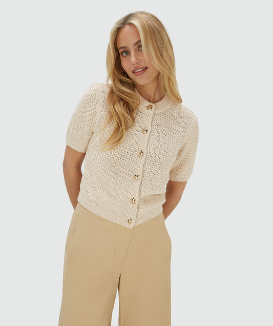 Image 14: Model draagt een ecrukleurig vest met een regular fit